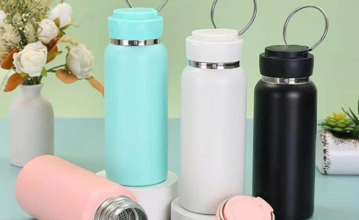 Bốn bình giữ nhiệt inox màu xanh mint, trắng, đen và hồng, nắp có quai xách bằng kim loại
